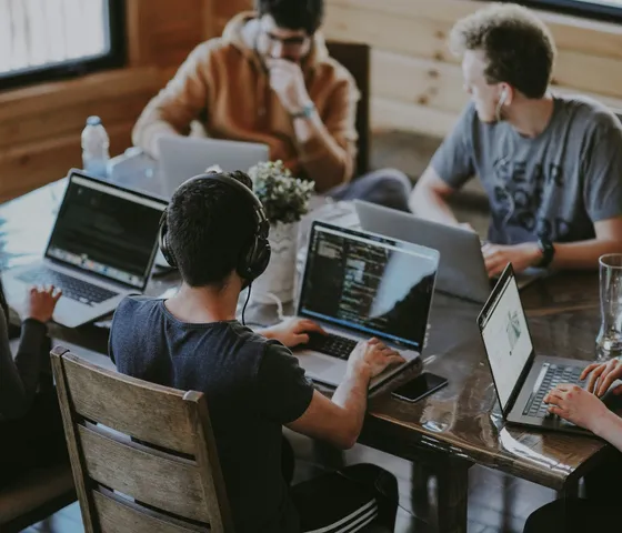 Engineers collaborating on code across multiple laptops